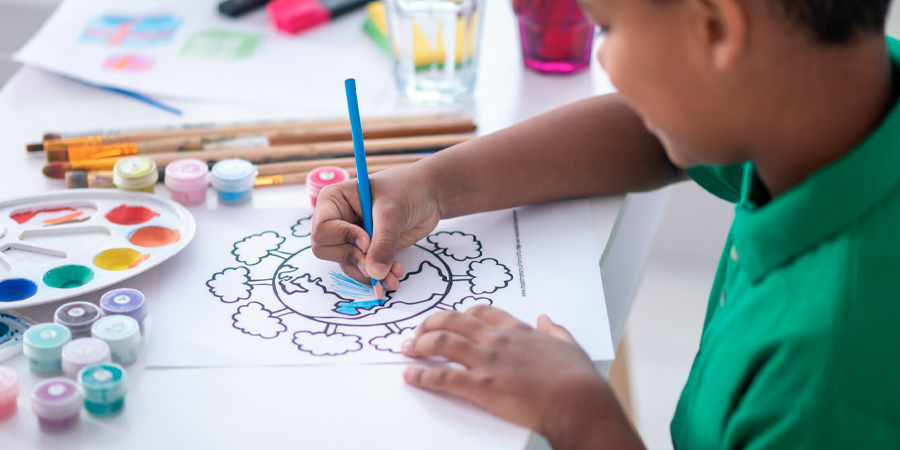 Criança com lápis de cor azul pintando um desenho