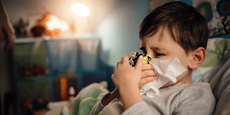 menino limpando o nariz e veja as orientações práticas para tratar a gripe infantil
