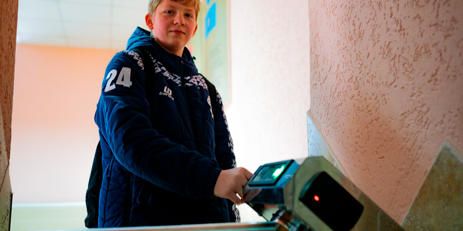 Aluno passando na catraca com identificação eletrônica da escola 