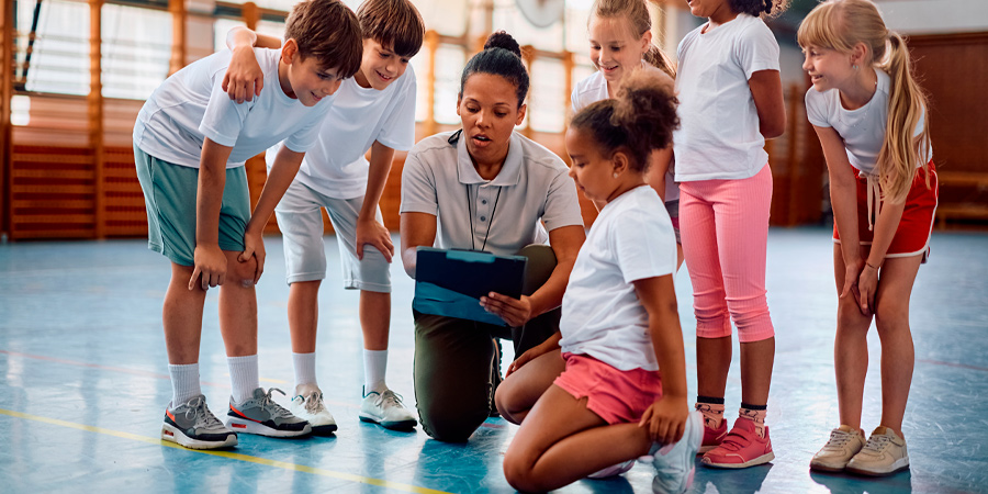 Alunos com professora durante aula de Educação Física